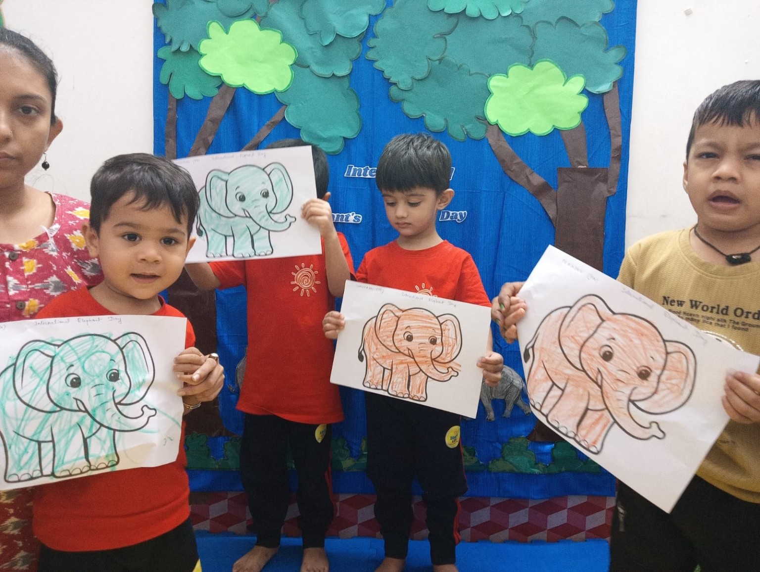 Children displaying elephant artwork